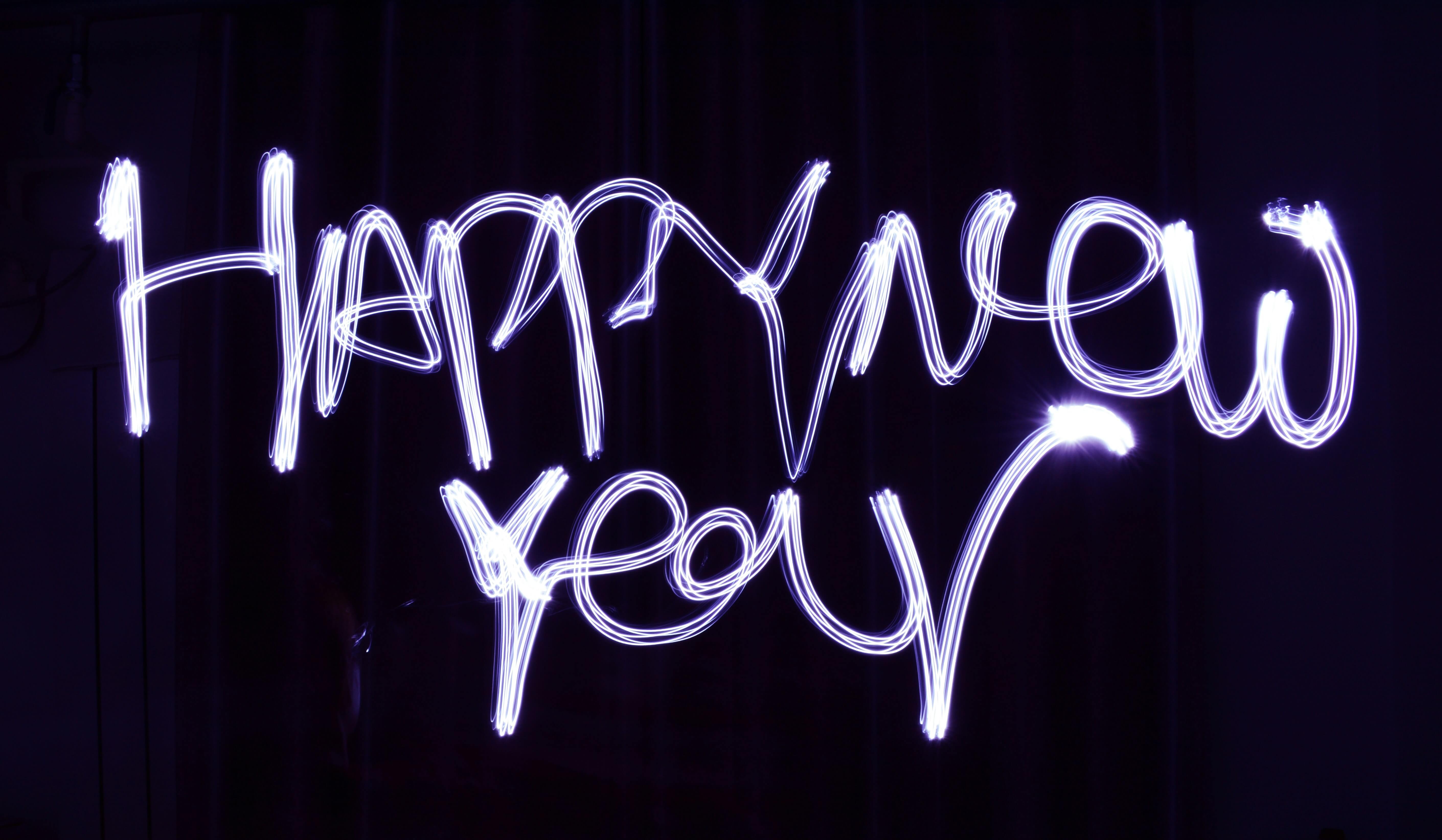 Happy New Year written in the air using a sparkler and long-exposure photograph